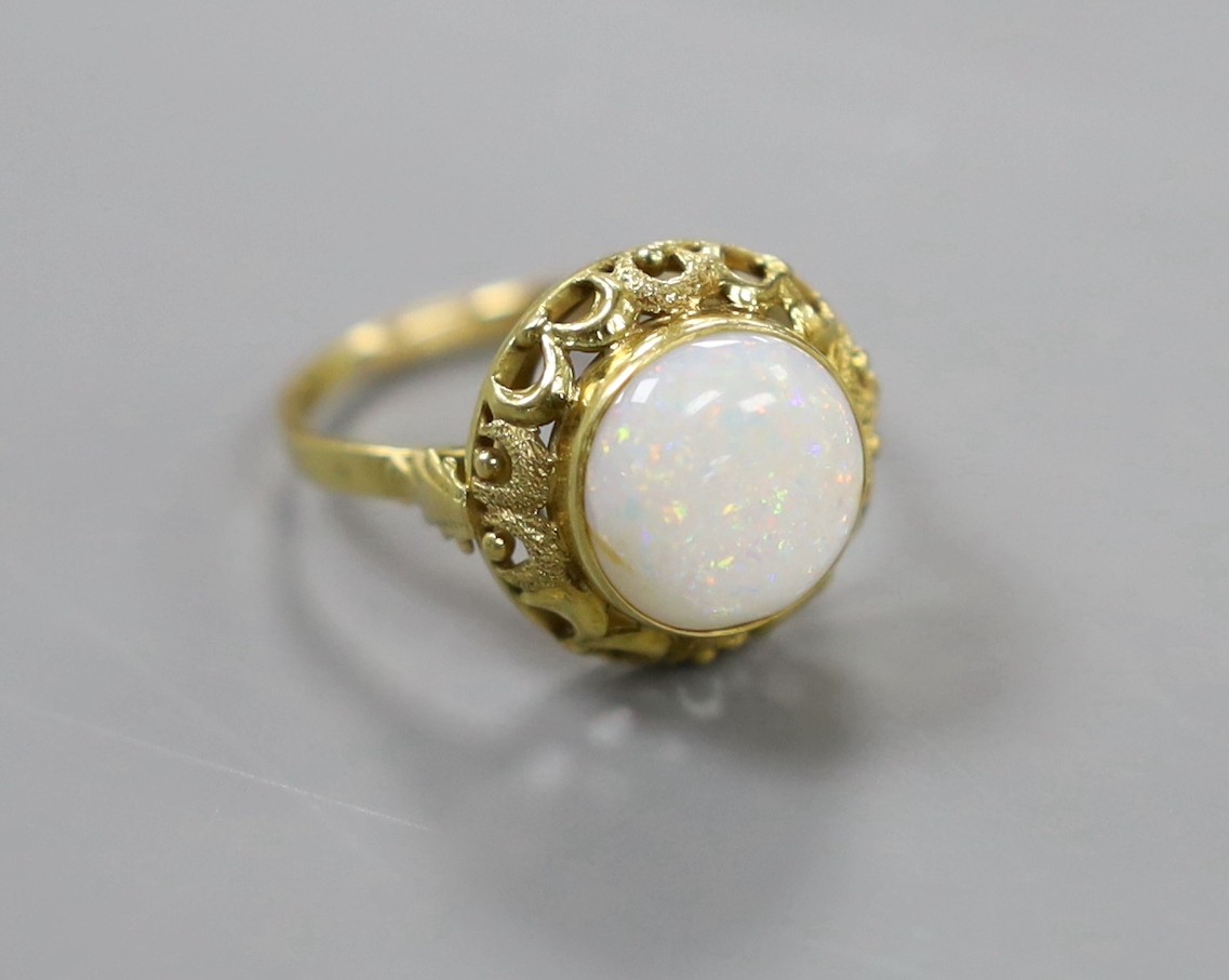 A 750 yellow metal and cabochon white opal set ring, with pierced setting, size U/V, gross weight 5 grams.